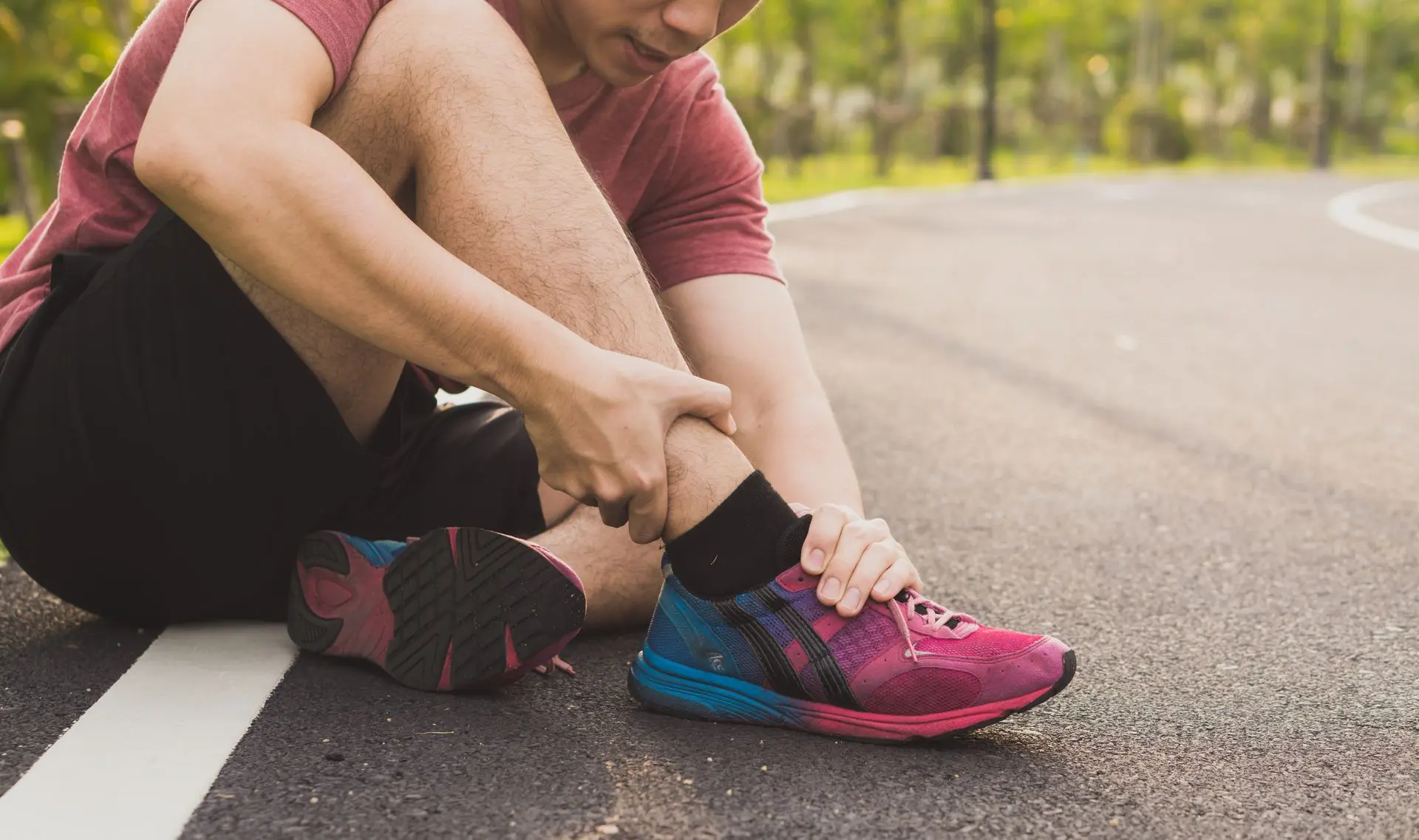 Corredor estirando los pies después del entrenamiento para evitar lesiones como la fascitis plantar.