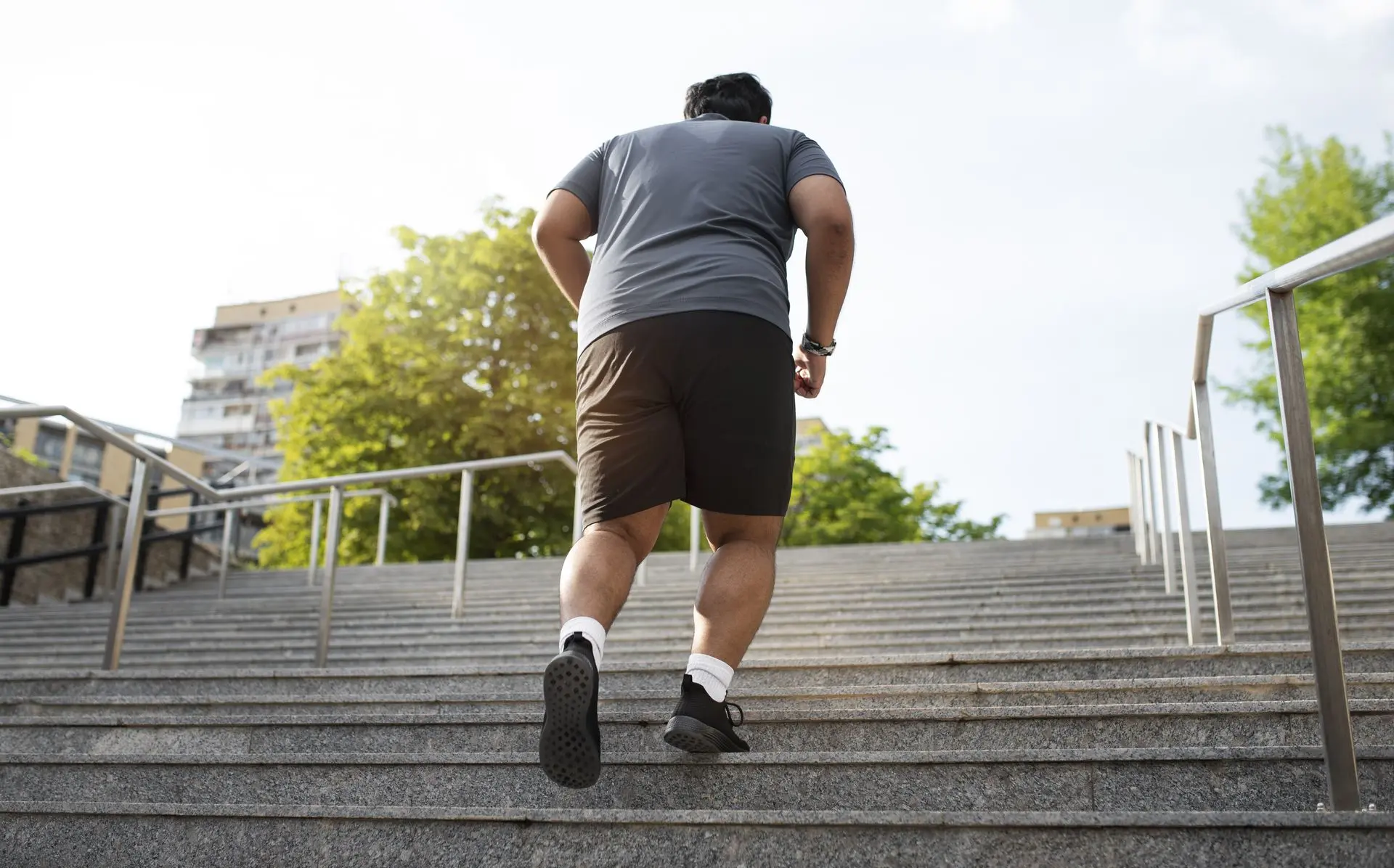 Persona con sobrepeso subiendo las escaleras