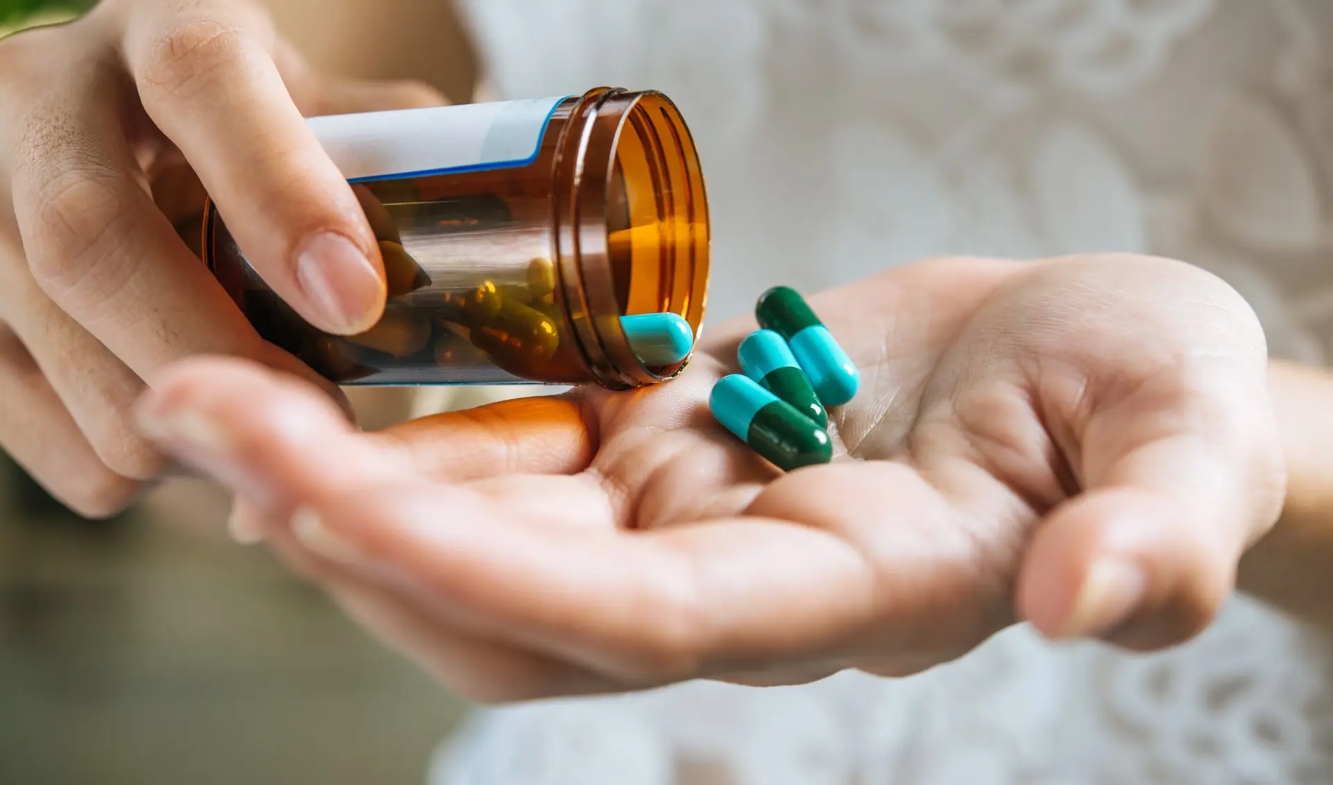 persona vaciando frasco con medicamentos